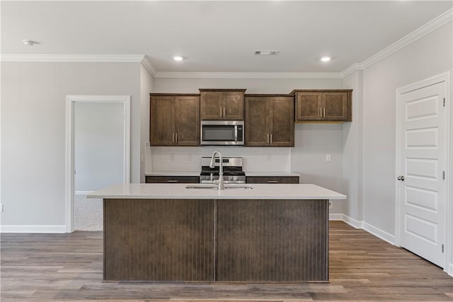 kitchen featuring visible vents, stainless steel appliances, wood finished floors, and light countertops