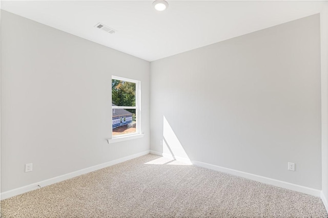 carpeted spare room with visible vents and baseboards