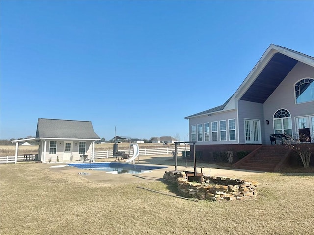 view of swimming pool with an outbuilding, a lawn, and a water slide