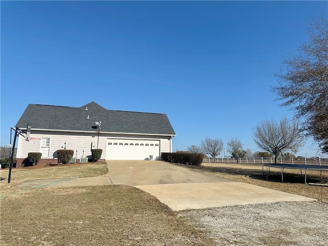 view of side of property featuring a garage and a trampoline