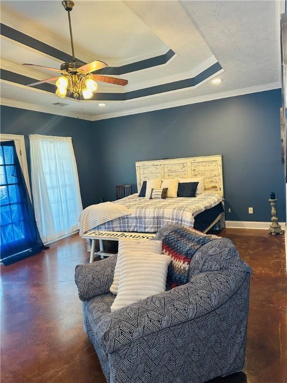 bedroom with ceiling fan, ornamental molding, and a tray ceiling