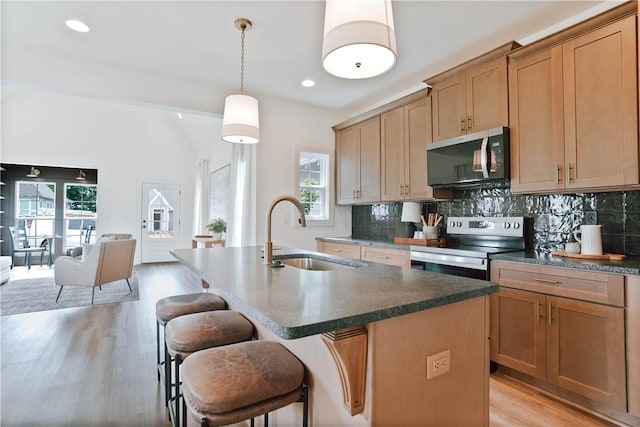 3228 Bradley Ln, Auburn, AL 36830 - kitchen featuring a sink, stainless steel appliances, backsplash, light wood-type flooring, and plenty of natural light