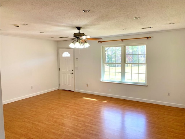 unfurnished room with baseboards, a textured ceiling, and light wood-style flooring