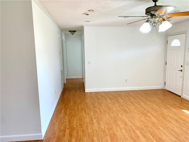 unfurnished room featuring a ceiling fan, baseboards, and light wood-type flooring