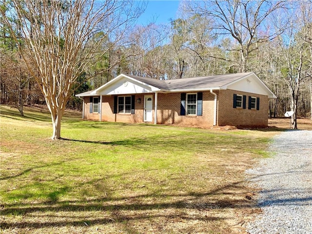 ranch-style house with brick siding, gravel driveway, and a front yard