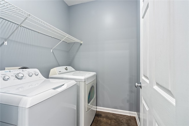 clothes washing area with washer and dryer, baseboards, and laundry area