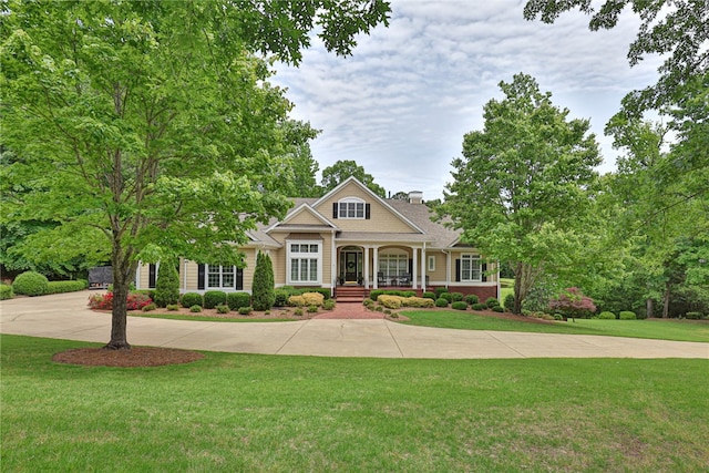 view of front of home with a porch, a front lawn, and a chimney