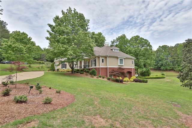 view of property exterior featuring brick siding and a yard