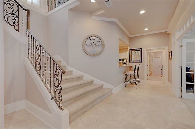 stairs with recessed lighting and crown molding