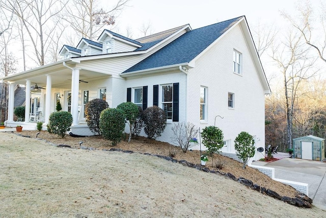 view of front of home featuring covered porch and a shed