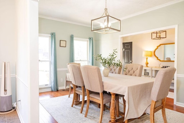 dining room with ornamental molding, a chandelier, and light hardwood / wood-style flooring