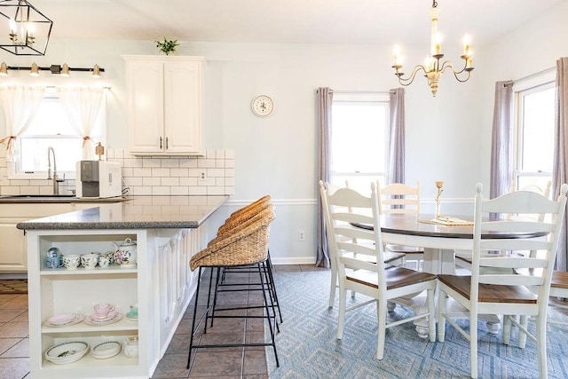 tiled dining room with a chandelier and sink