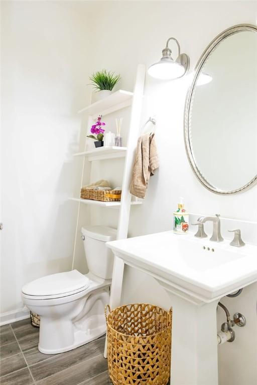 bathroom with wood-type flooring and toilet