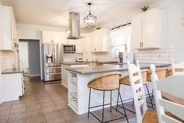 kitchen featuring sink, pendant lighting, island exhaust hood, stainless steel appliances, and white cabinets