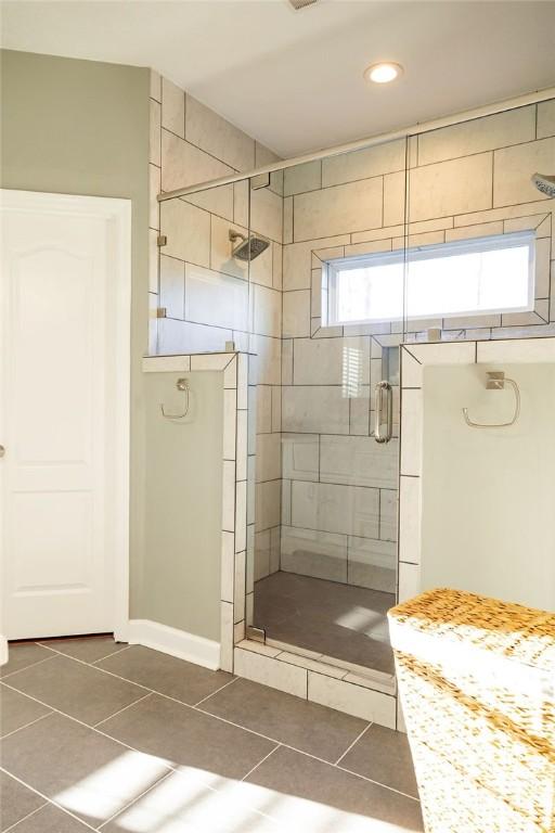 bathroom featuring a shower with shower door and tile patterned floors