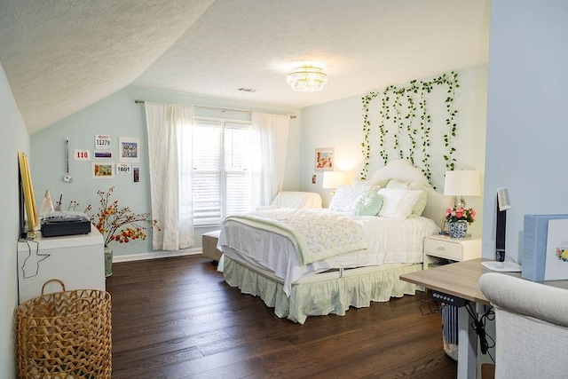 bedroom with vaulted ceiling, dark hardwood / wood-style floors, and a textured ceiling