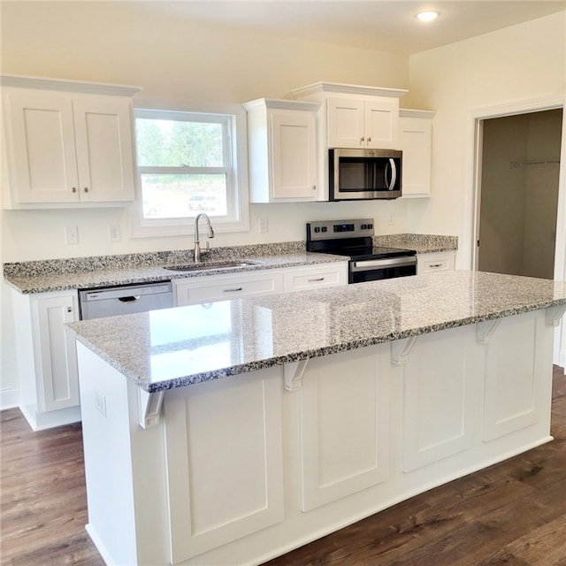 705 Riverside Ests, Lanett, AL 36863 - kitchen with a kitchen breakfast bar, white cabinets, appliances with stainless steel finishes, and a sink