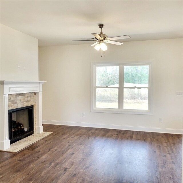 705 Riverside Ests, Lanett, AL 36863 - unfurnished living room featuring a brick fireplace, baseboards, dark wood-style flooring, and ceiling fan