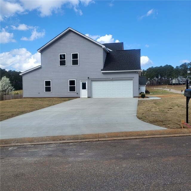 705 Riverside Ests, Lanett, AL 36863 - view of side of property with an attached garage, concrete driveway, a yard, and a shingled roof