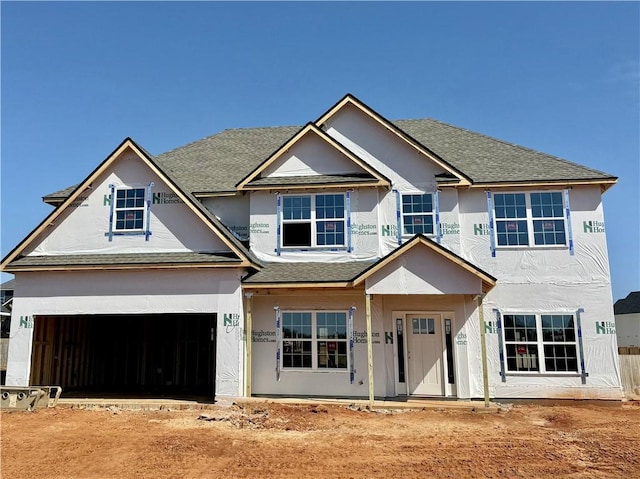 view of front of property with a garage, stucco siding, and roof with shingles