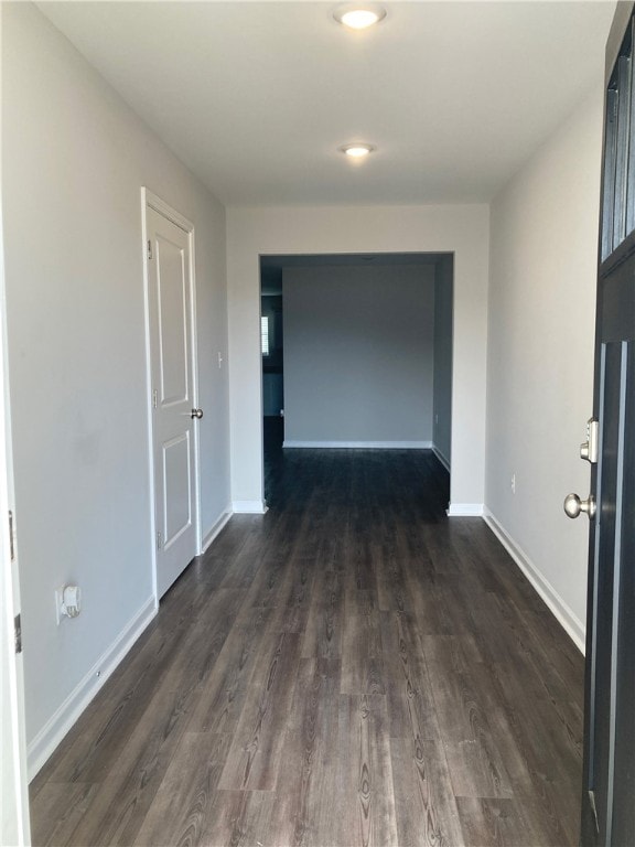 corridor featuring dark wood-style floors and baseboards