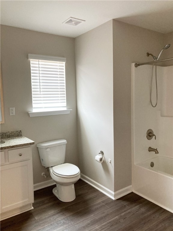 full bathroom featuring visible vents, toilet, wood finished floors, vanity, and shower / bathing tub combination