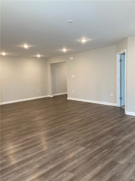 empty room featuring dark wood-style flooring, recessed lighting, and baseboards