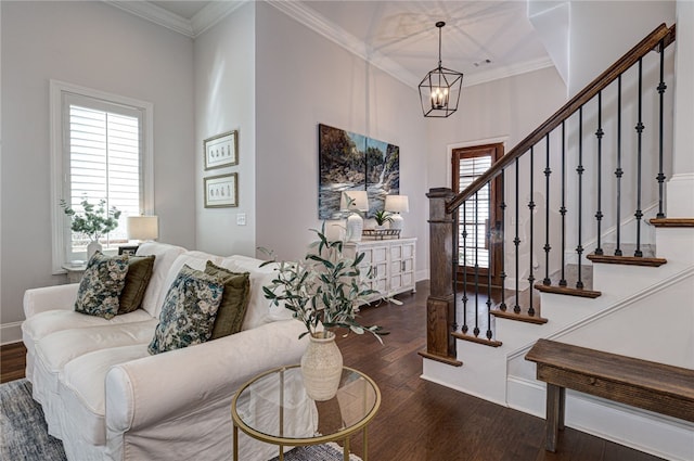 living room featuring dark hardwood / wood-style flooring, ornamental molding, and an inviting chandelier