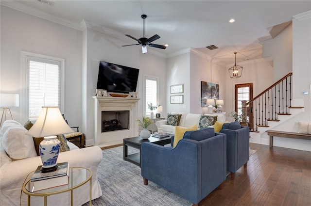 living room featuring dark hardwood / wood-style floors, ceiling fan, and ornamental molding