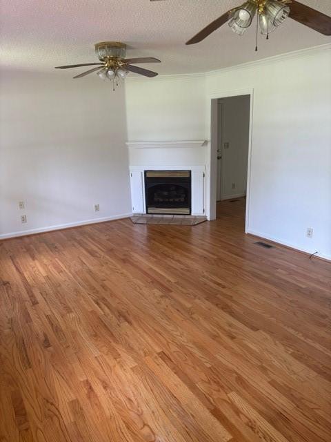 2420 38th Blvd, Valley, AL 36854 - unfurnished living room featuring a ceiling fan, wood finished floors, a fireplace, and baseboards