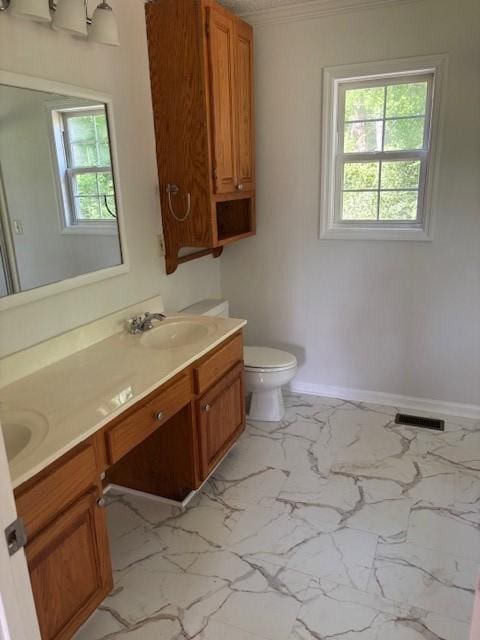 2420 38th Blvd, Valley, AL 36854 - full bathroom with double vanity, marble finish floors, toilet, baseboards, and crown molding