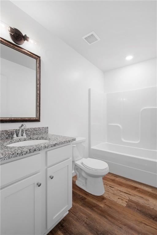 full bathroom featuring toilet, shower / bath combination, vanity, and hardwood / wood-style floors