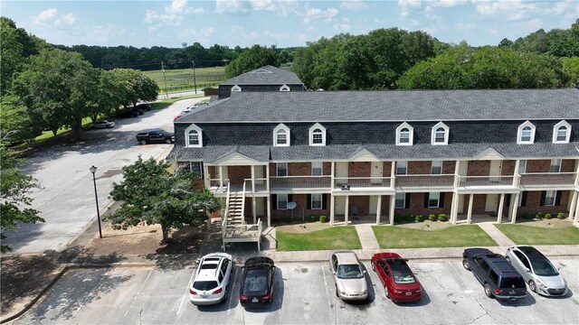 1761 Wire Rd Unit 409, Auburn, AL 36830 - view of front facade with roof with shingles, brick siding, uncovered parking, and stairs