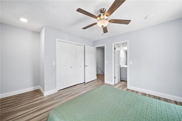 1761 Wire Rd Unit 409, Auburn, AL 36830 - bedroom with light wood finished floors, a closet, a ceiling fan, and connected bathroom