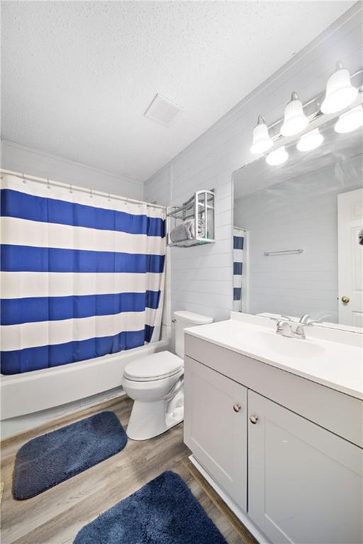 1761 Wire Rd Unit 409, Auburn, AL 36830 - bathroom with vanity, wood finished floors, a textured ceiling, and shower / tub combo