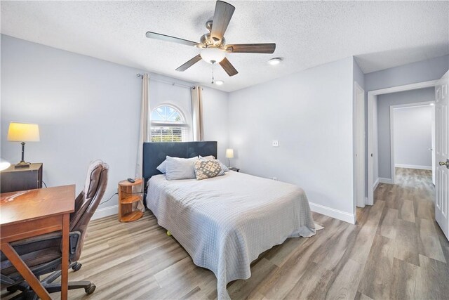 1761 Wire Rd Unit 409, Auburn, AL 36830 - bedroom with light wood-type flooring, a textured ceiling, a desk, and ceiling fan