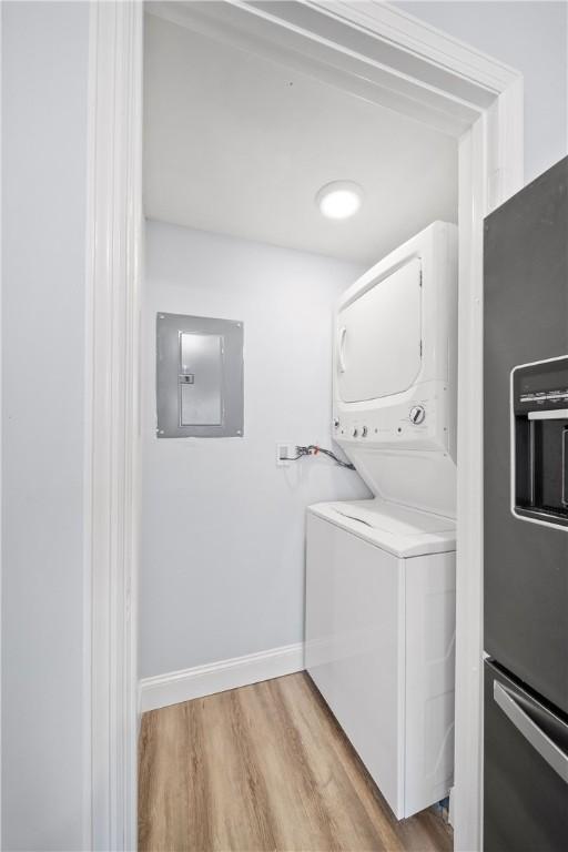 1761 Wire Rd Unit 409, Auburn, AL 36830 - laundry area with electric panel, stacked washer and clothes dryer, and light wood-type flooring
