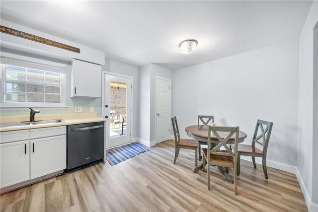 1761 Wire Rd Unit 409, Auburn, AL 36830 - kitchen with stainless steel dishwasher, light wood-style floors, tasteful backsplash, and healthy amount of natural light