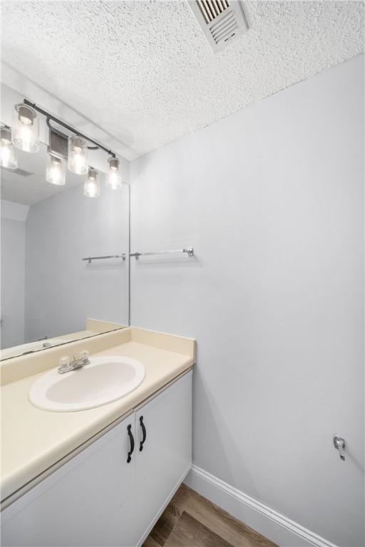 1761 Wire Rd Unit 409, Auburn, AL 36830 - bathroom featuring a textured ceiling, vanity, and wood finished floors
