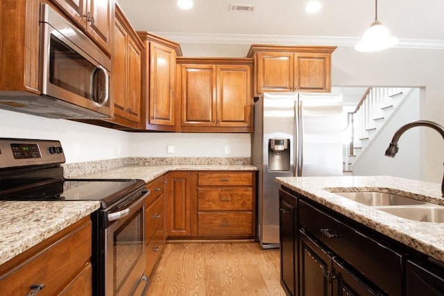 kitchen with sink, crown molding, stainless steel appliances, and light wood-type flooring