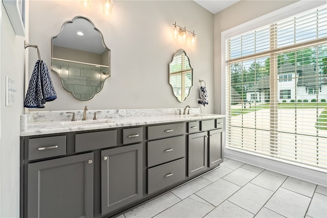 bathroom with tile patterned flooring, a sink, walk in shower, and double vanity