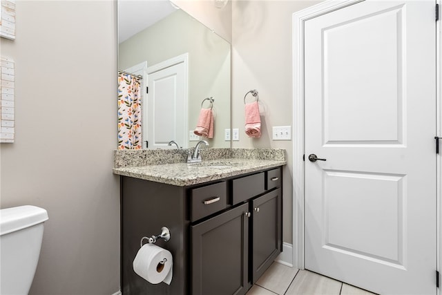 bathroom featuring vanity, tile patterned flooring, and toilet