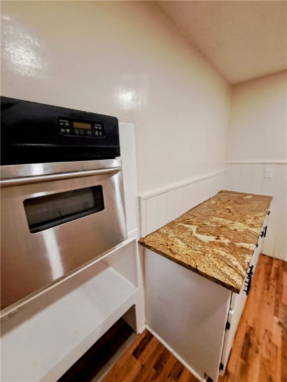 kitchen featuring oven and hardwood / wood-style floors