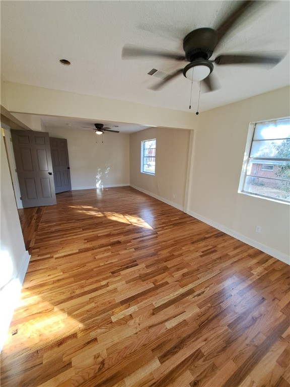 empty room with light hardwood / wood-style flooring and ceiling fan