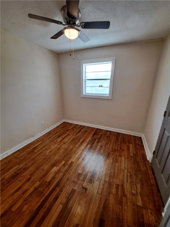 unfurnished room with dark hardwood / wood-style flooring and a textured ceiling