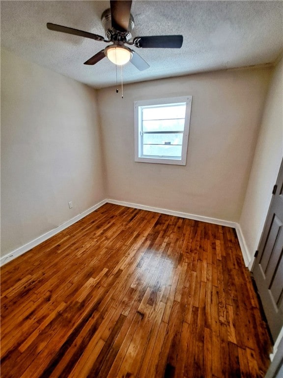 unfurnished room with dark hardwood / wood-style floors and a textured ceiling