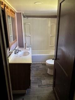 bathroom with vanity, shower / bathing tub combination, and toilet