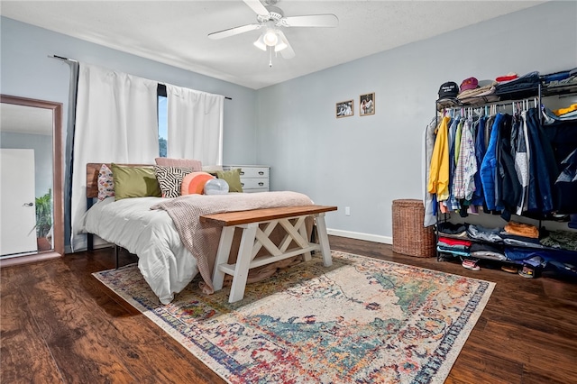 bedroom with dark hardwood / wood-style flooring and ceiling fan