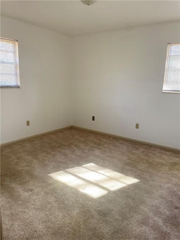 carpeted spare room with baseboards