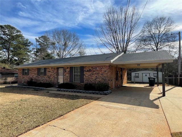 single story home with driveway, an attached carport, fence, and brick siding